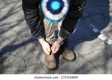 Man On Street Leaned Over And Tied Shoelaces. Walk In Park During Quarantine. Fresh Air Activates Bodys Defenses. Pandemic Breach Emergency. Guy In Casual Clothes Is Standing On Pavement