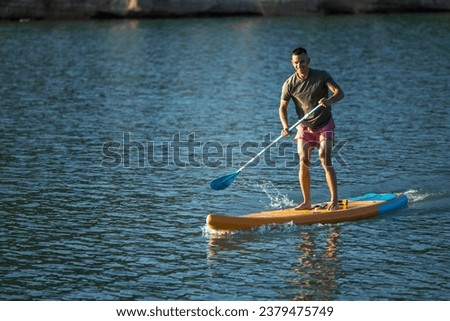 Man on sub board floating on ocean sea.