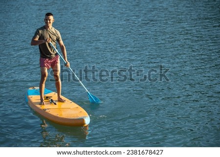 Man on sub board floating on ocean sea.