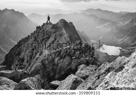 man on the top of the mountains looking to sunset. Black and white photo