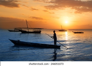 Man On A Traditional Boat Off The Coast Of Zanzibar At Sunset