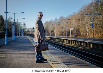 Man Is On The Train Station With Travel Bag, Waits For A Train. Main UK Railway Route To Central London