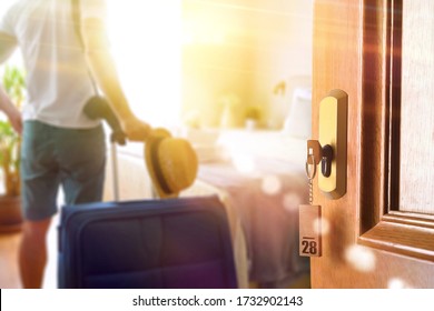 Man On Vacation Entering A Bright Hotel Room With Open Door And Key Set