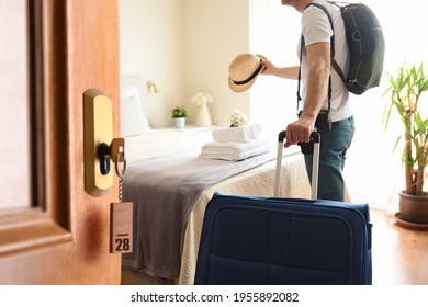 Man On Vacation Entering A Bright Hotel Room With Open Door And Key Set