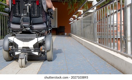 Man on wheelchair driving on accessible ramp