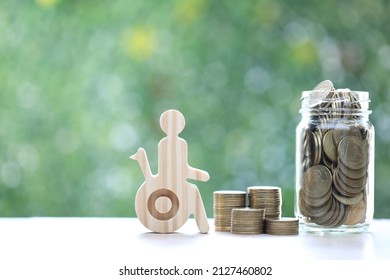 Man on wheelchair and gold coin money in the glass bottle on natural green background,Save money for prepare in future and handicapped person concept