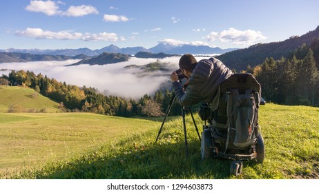 man on wheelchair taking photos of beautiful landscape in a foggy morning, St. Thomas Slovenia - Powered by Shutterstock