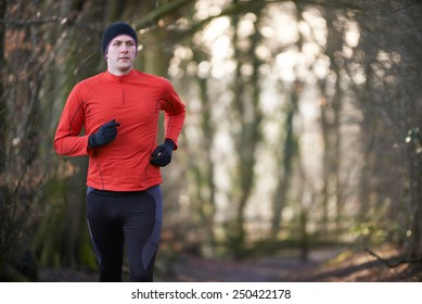 Man On Winter Run Through Woodland