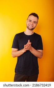 A Man On A Yellow Background Holds His Hands In Front Of Him With A Sly Look - The Emotions Of A Man