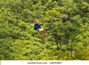 Man On Zipline Over Lush Tropical Valley