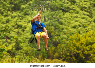 Man On Zipline Over Lush Tropical Valley