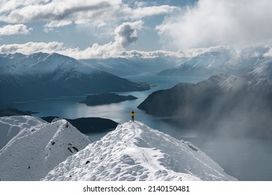 Man with open arms at Roy's Peak iconic lookout in winter season. Wanaka, Otago, New Zealand