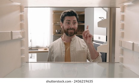 Man open empty refrigerator need food delivery shopping buying product smiling rise finger has good idea gesture find solution order meal courier smile happy insight point of view from inside fridge