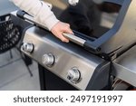 Man open lid and checking fire in bbq grill, looking if burned down to hot coals ready for cooking meat. Barbeque equipment, outdoors kitchen concepts