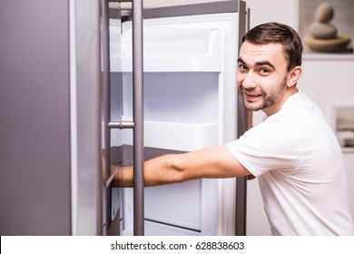 Man Open Refrigerator Door In The Kitchen At Home