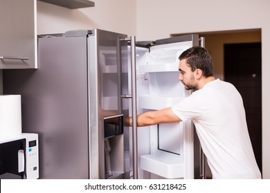 Man Open Refrigerator Door In The Kitchen