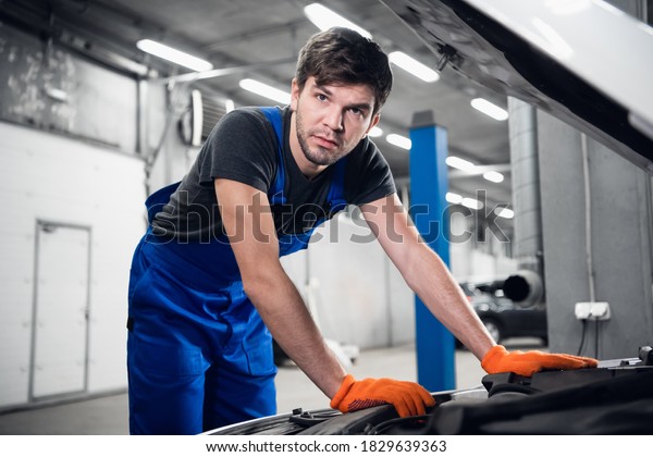 The\
man opened the hood of the car and checks the\
engine