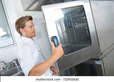 man opening the big oven - Powered by Shutterstock