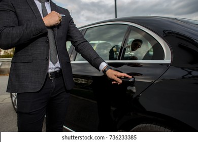 Man opening a black car limousines door