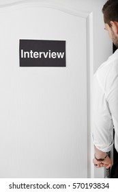 Man Opening Door With Black Signboard