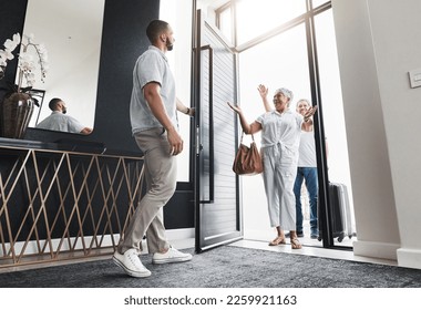 Man opening door, family visit and holiday with smile, loving and bonding together, care and vacation. Love, male invite parents into home and happiness with joy, excited and welcome with greeting - Powered by Shutterstock