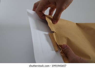 A Man Opening His Mail Envelope With His Hand