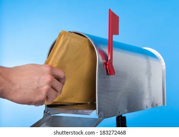 Man Opening His Mailbox To Remove Mail Inside  Close Up Of His Hand On The Open Door Against A Blue Sky