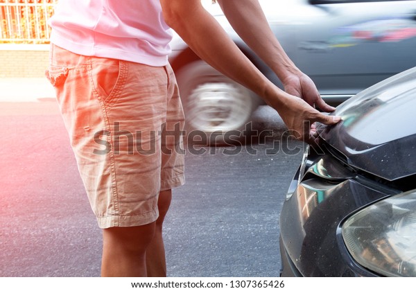 Man\
opening   the hood of  car to check the\
engine.