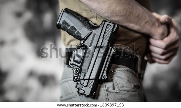 Man openly carrying a pistol on his\
belt. Open carry and second amendment\
concept.
