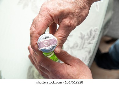 The Man Opens A Bottle Of Alcohol, Breaking The Excise Duty.