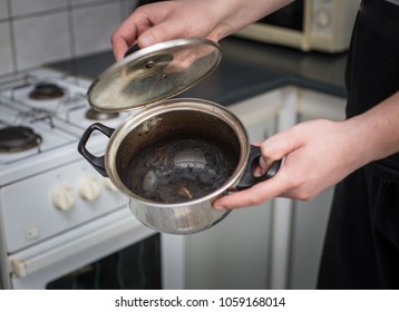 the man opens a burnt empty pot