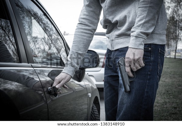 man opens the car door\
with a gun in his hand. the criminal steals the car. criminal\
district of the city