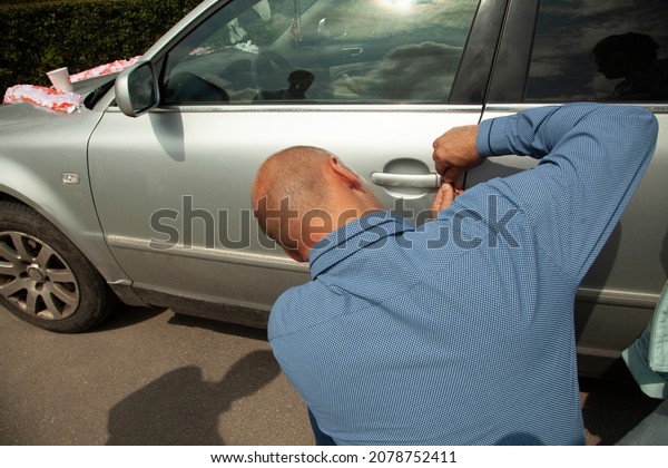 The man opens the car door. The guy lost\
his car key. A man tries to open a\
vehicle.