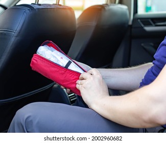 A Man Opens A Car First Aid Kit In The Car. The Concept Of First Aid To The Injured Person In A Road Traffic Accident, Treatment