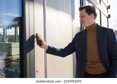 Man Opens Door Of House With Phone. Locking Locks With Digital Modern Technology. Smart Home.