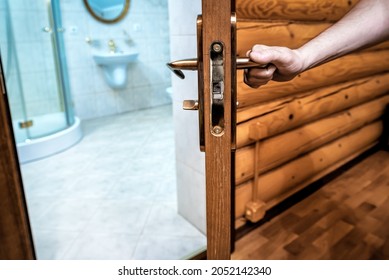 Man Opens The Door Knob To The Bathroom