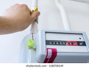 The Man Opens The Gas Valve On The Gas Meter. Heating In Winter, Conceptual Image Of Energy Saving. Part Of Body, Selective Focus.