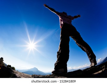 Man opens his arms in the sunshine against blue sky. Concept: freedom, success, energy, vitality. - Shutterstock ID 152841809