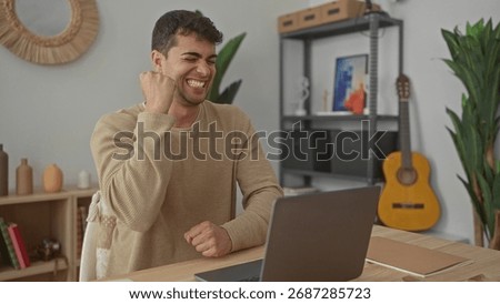 Man opens laptop while typing messages at home where young hispanic male enjoys computer sessions in a room workspace.