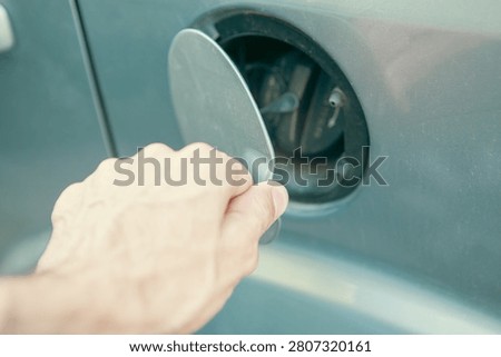 a man opens the lid of a tank