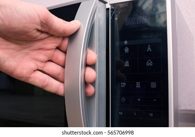 Man Opens Microwave In The Kitchen