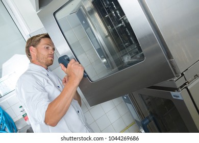 Man Opens An Oven Door