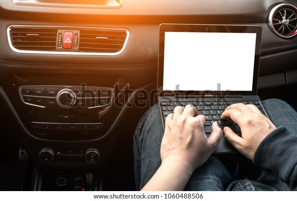 The man is operating\
a computer in a car