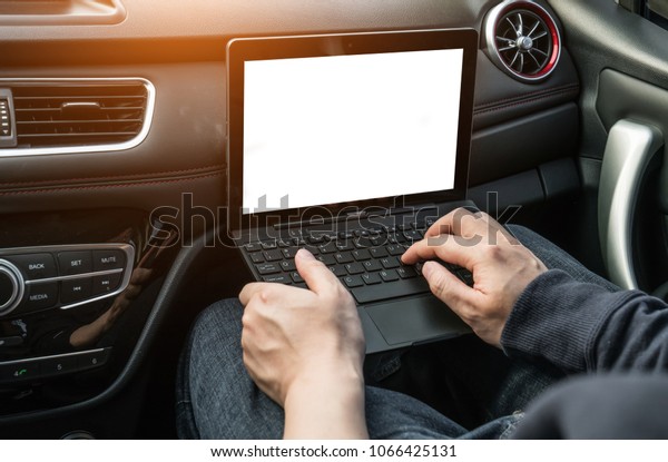 The man is operating\
a computer in a car