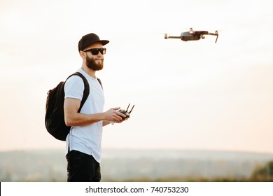 Man operating the drone by remote control and having fun 