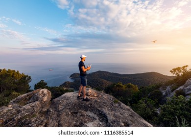 Man operating a drone using a remote controller.Man using drone at sunset for photos and video making 