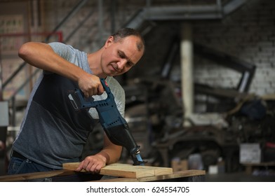 The Man Operating The Saber Saw In The Workshop