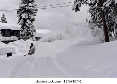 Man Operating A Snow Low Outside A House In Very Deep Snow, South Lake Tahoe, California