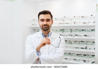 Man Optician With Glasses In Coat At Optics Store