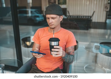 Man In Orange T-shirt Drinking Coffee From Reusable Coffee Cup